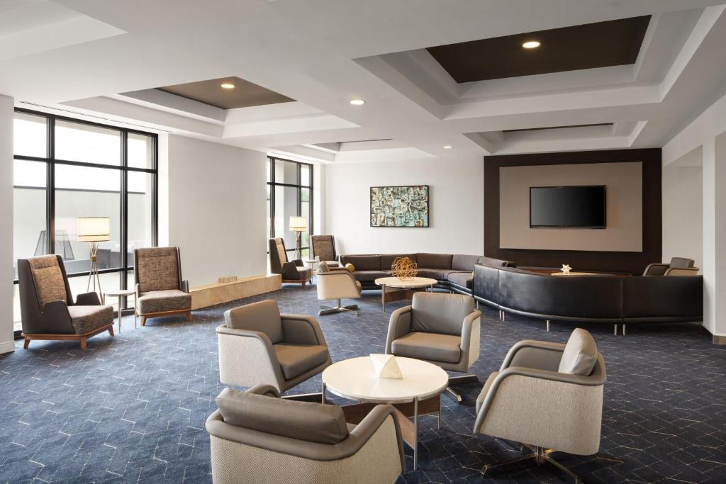 路易斯威尔路易斯维尔机场万怡酒店的大堂配有沙发、椅子和电视。