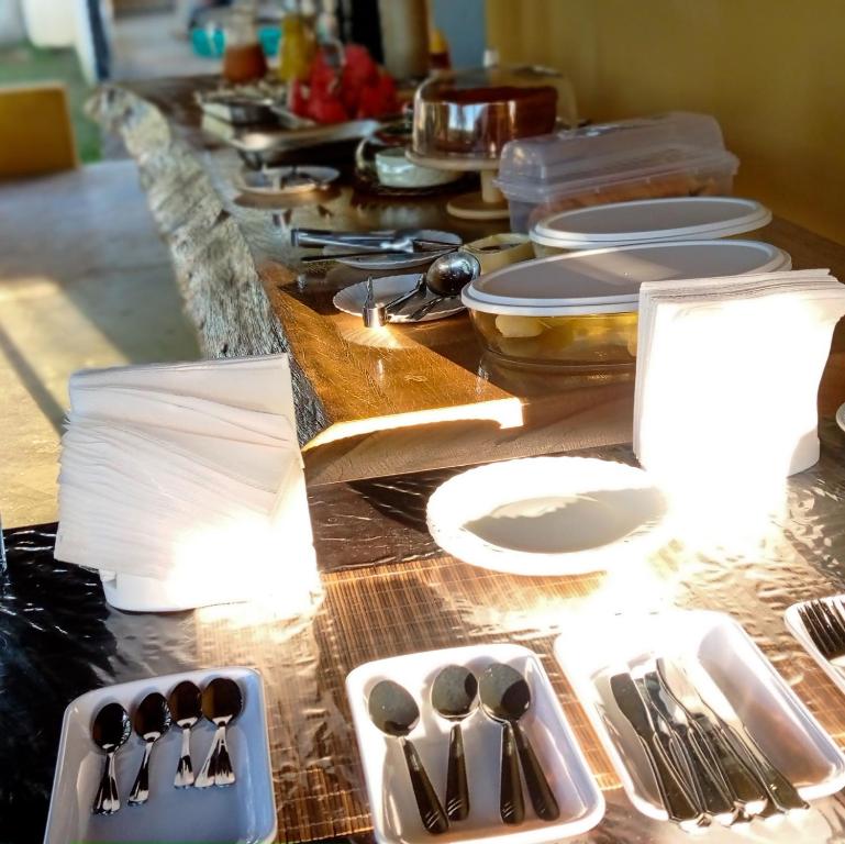 Sao Domingos de GoiasPousada Diadorim的一张长桌子,上面有盘子和餐具