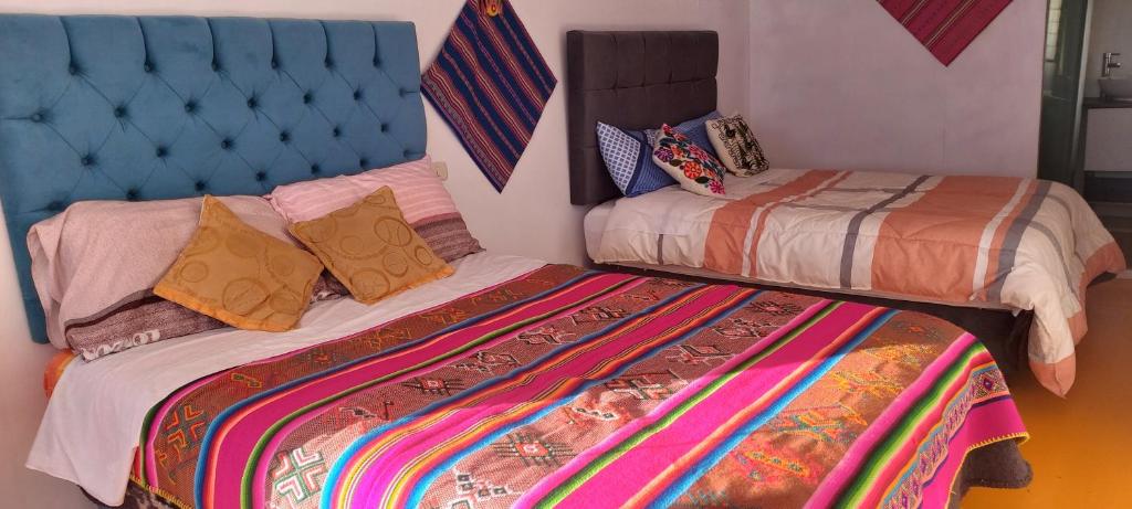 普诺Uros TITICACA home lodge的一间卧室设有两张床和蓝色床头板