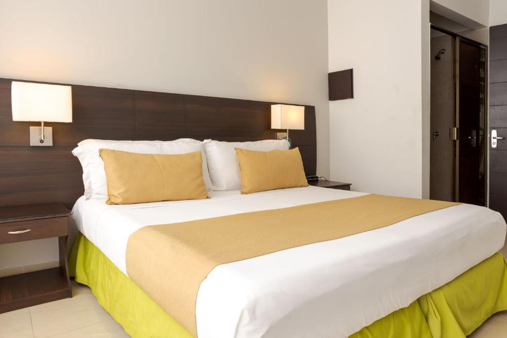 梅尔加Hotel Manantial Melgar Torre 2的一张大床,位于酒店客房内,配有黄色枕头