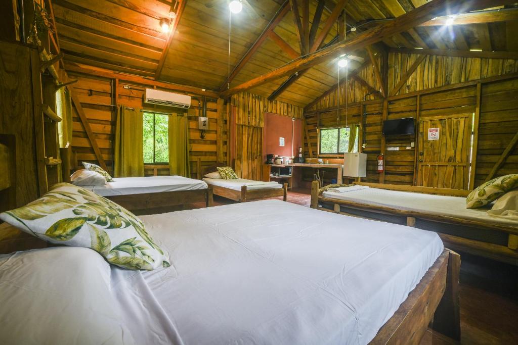 戈尔菲托Canto del Tucán Lodge and Farm的小木屋内一间卧室,配有两张床