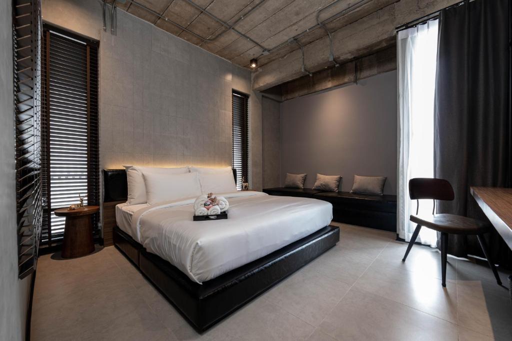 Ban Bang Khen (1)EX2 Hotel的卧室配有一张白色的大床和一张沙发。