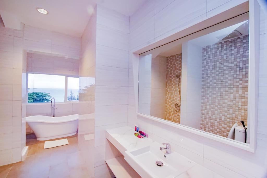 TanjungbingaDafam Resort Belitung的带浴缸、水槽和镜子的浴室