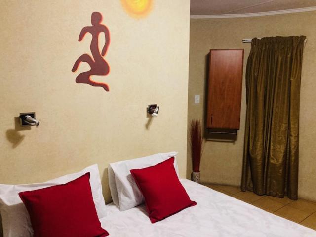 伊登维尔Eagle Crest Executive Lodge的一间卧室配有一张带两个红色枕头的床