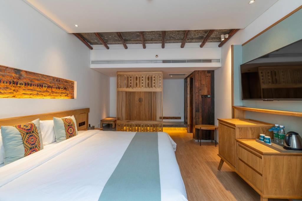 张家界Yoba Boutique Hotel的一间带大床和电视的卧室