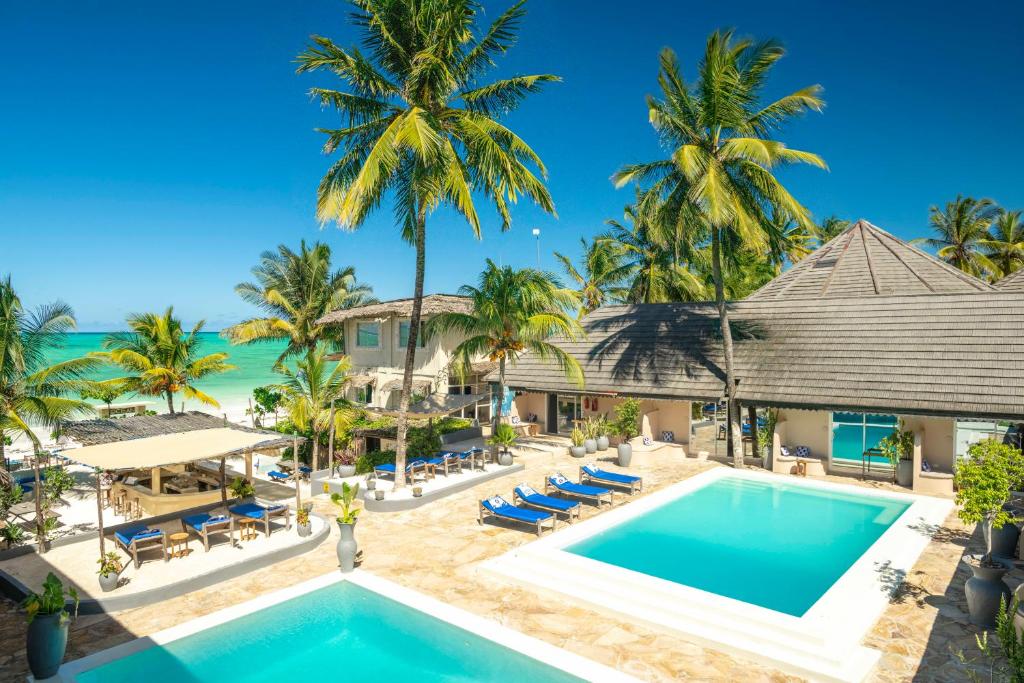 帕杰Paje Beach Apartments & Hotel的享有度假村的空中景致,设有游泳池和棕榈树