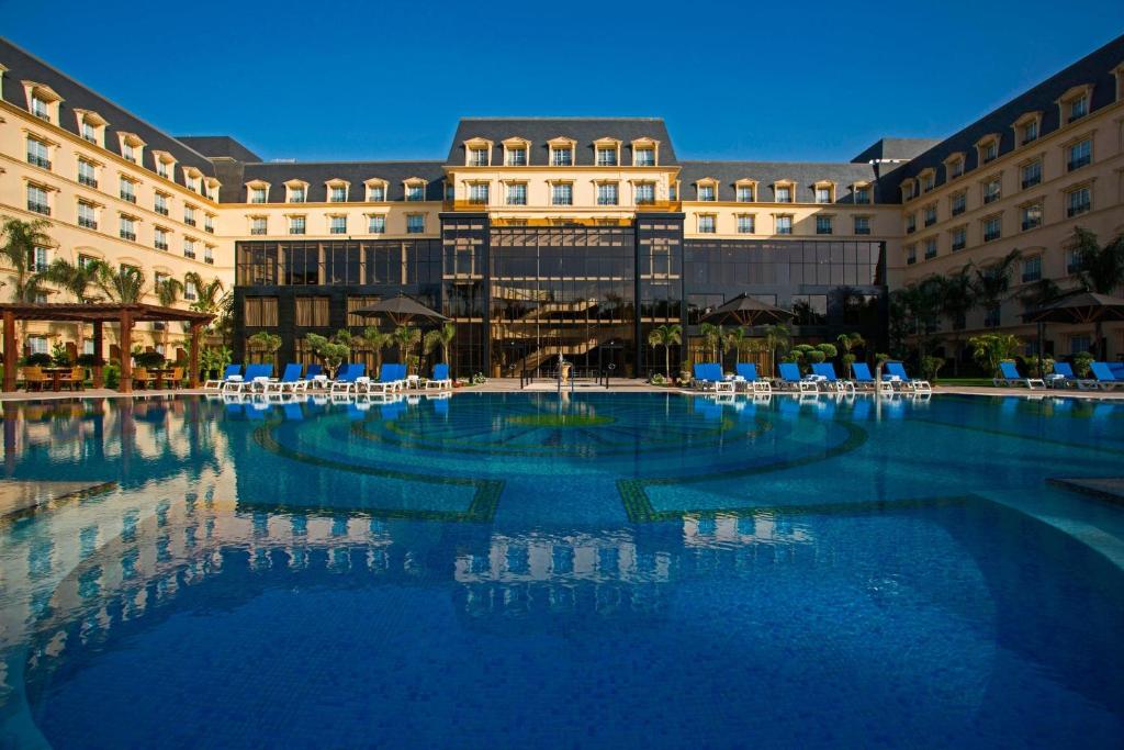 开罗Renaissance Cairo Mirage City Hotel的大楼前的大型游泳池