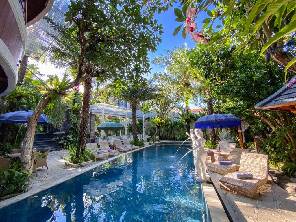 坎古巴厘梦幻别墅回声海滩加努度假酒店的度假村的游泳池,配有椅子和遮阳伞