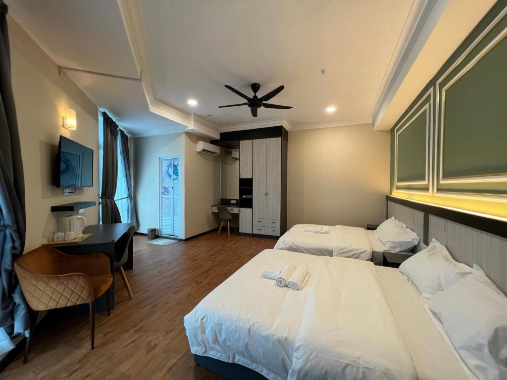 Kota BharuAlia Express Dey Hotel Kota Bharu的酒店客房配有两张床和吊扇。