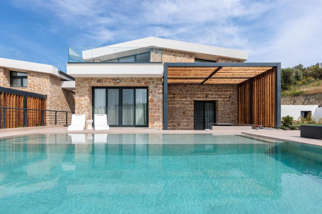 卡兰兹拉Five Senses Of Luxury的房屋前有游泳池的房子