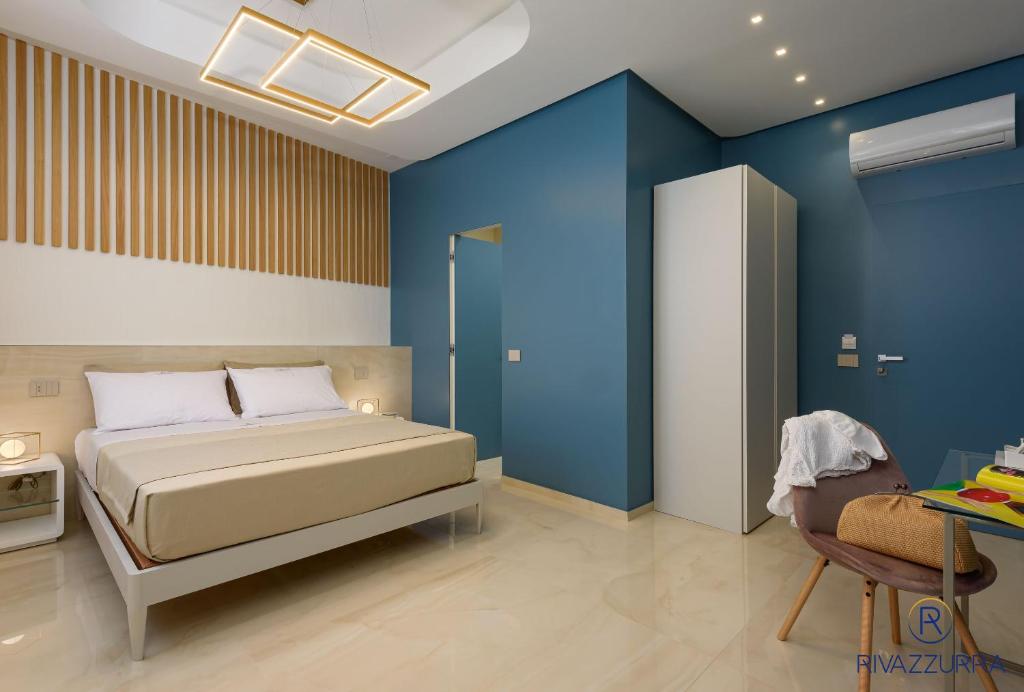 圣维托罗卡波Rivazzurra Beach Rooms的一间卧室设有一张床和蓝色的墙壁