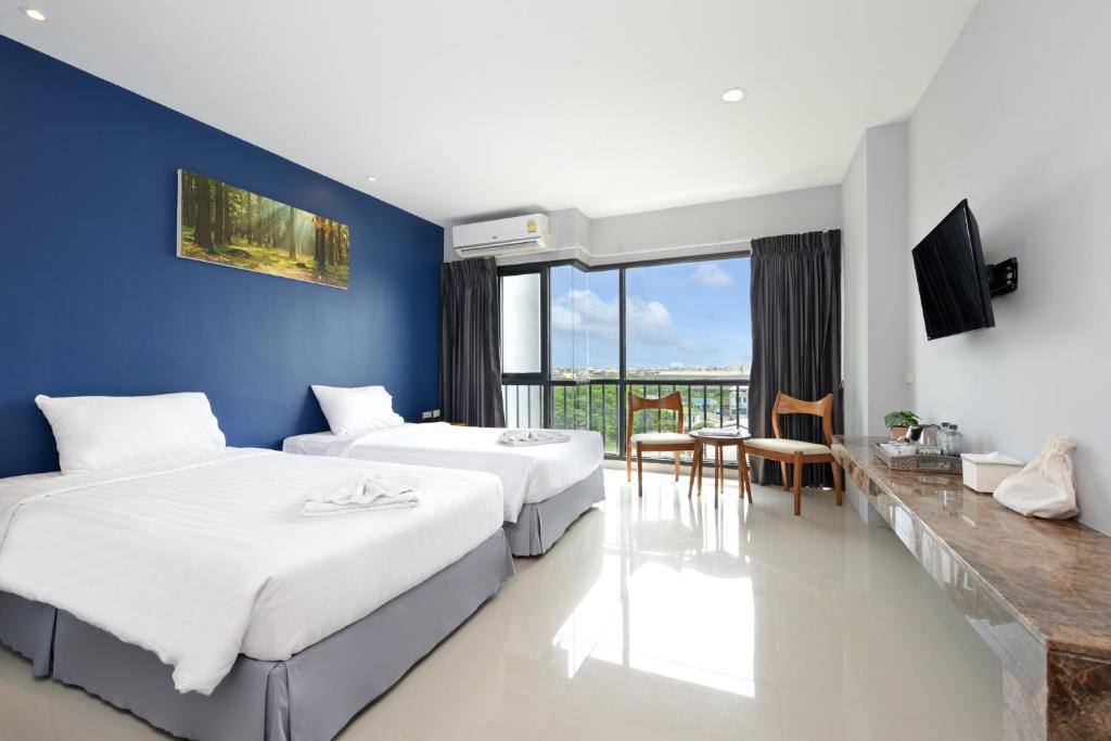 Ban Khlong Bang PingVST Residence -SHA PLUS Certified的一间卧室设有两张床和蓝色的墙壁