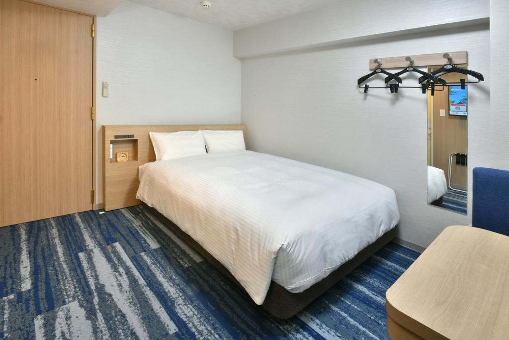名古屋名古屋荣华盛顿广场酒店的卧室配有一张白色大床