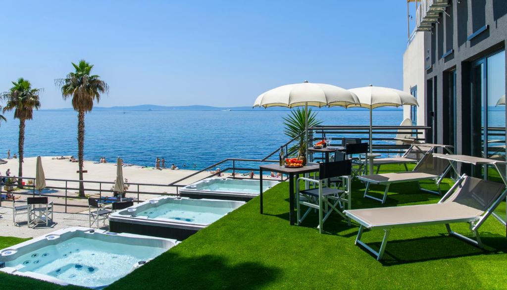斯普利特Via Mare Luxury Rooms的一个带桌椅的海景庭院
