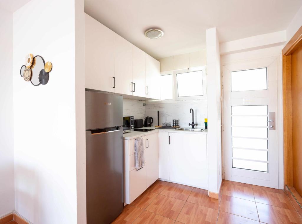 梅罗那瑞斯Apartamento Maypa 5 Mar的厨房铺有木地板,配有白色橱柜。