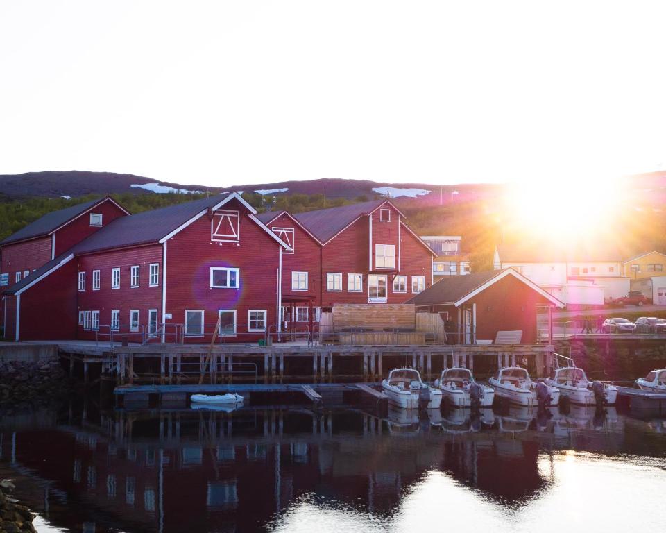 巴特斯峡湾Båtsfjord Brygge - Arctic Resort的一群船停靠在一座红色建筑前面