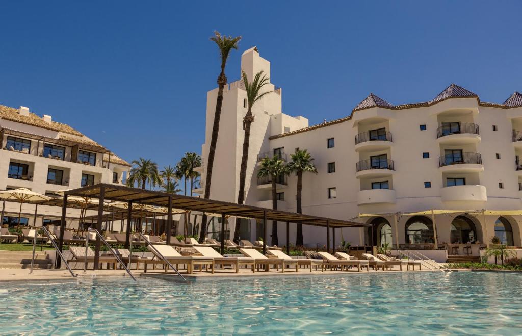 米哈斯La Zambra Resort GL, part of The Unbound Collection by Hyatt的一座带椅子和建筑物的酒店游泳池