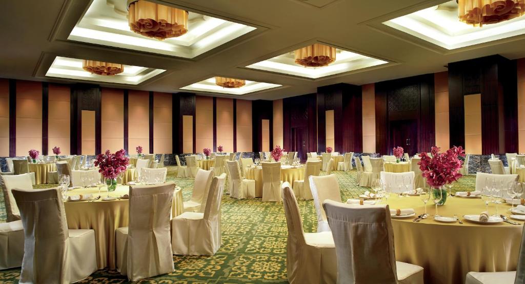 班加罗尔班加罗尔丽思卡尔顿酒店的宴会厅配有白色的桌椅