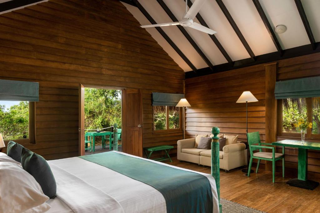 雅拉Jetwing Safari Camp的一间卧室设有一张床和一间客厅。
