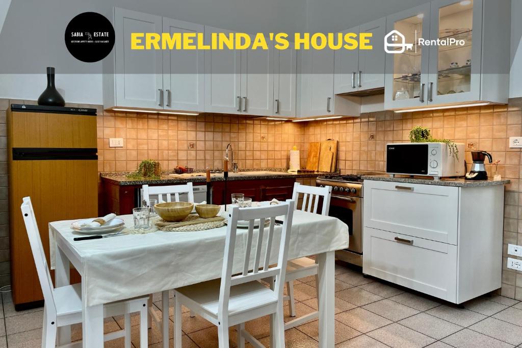 Arnasco[Menosio] La casa di Ermelinda - Relax的厨房配有白色的桌椅和微波炉