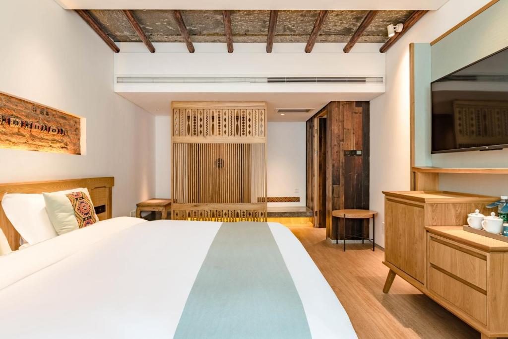 张家界Yoba Boutique Hotel的一间带大床和电视的卧室