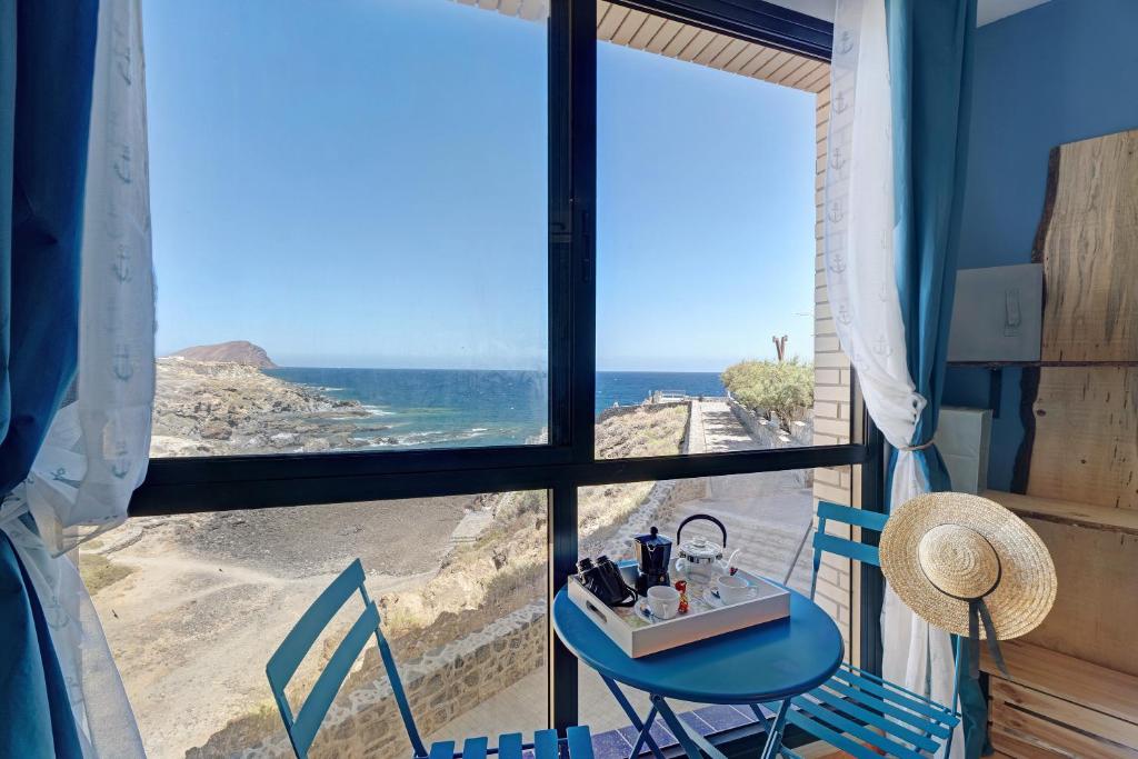 阿布里斯Los Abrigos oceano al alba wifi的配有桌椅的海景客房