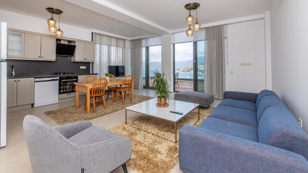 博德鲁姆Villa House Sea View Türkbükü的一间带蓝色沙发和椅子的客厅和一间厨房