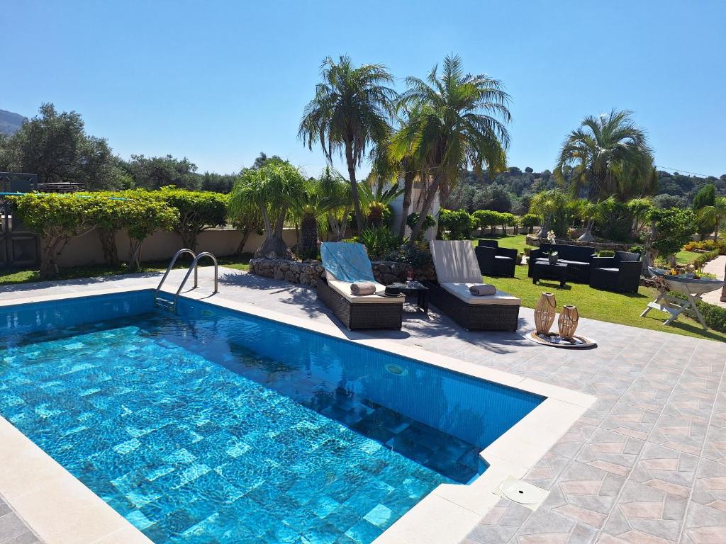 哈拉奇Villa Maria的庭院内一个带两把躺椅的游泳池