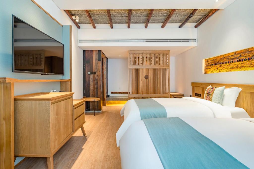 张家界Yoba Boutique Hotel的有两张床和一台电视的酒店房间