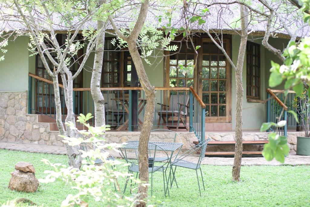 布拉瓦约Twin bed lodge on natural African bush - 2111的房子前面的一张桌子和椅子