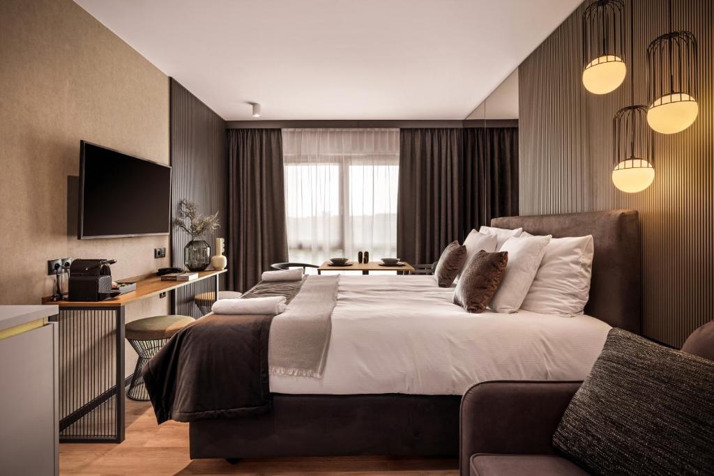 格但斯克Royal Apartments - Boutique Residence Gdańsk的酒店客房设有一张大床和一张书桌。