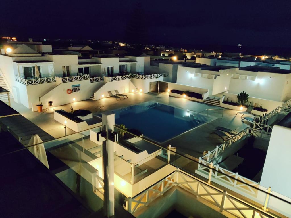 宏达海滩Casa Ila Flower Beach的享有大楼的顶部景色,在晚上设有游泳池