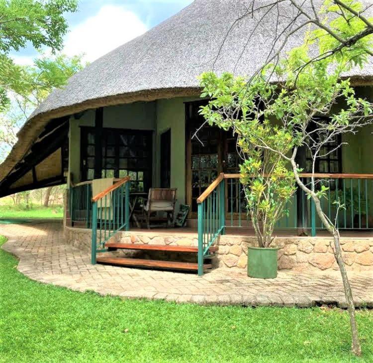 布拉瓦约Double lodge on natural African bush - 2112的一座带茅草屋顶的绿色小房子
