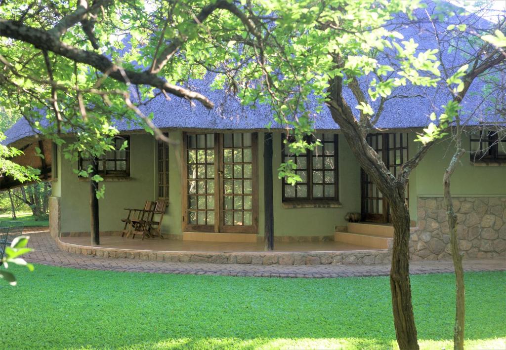 布拉瓦约Family Lodge in Natural African bush - 2113的前面有棵树的绿色房子