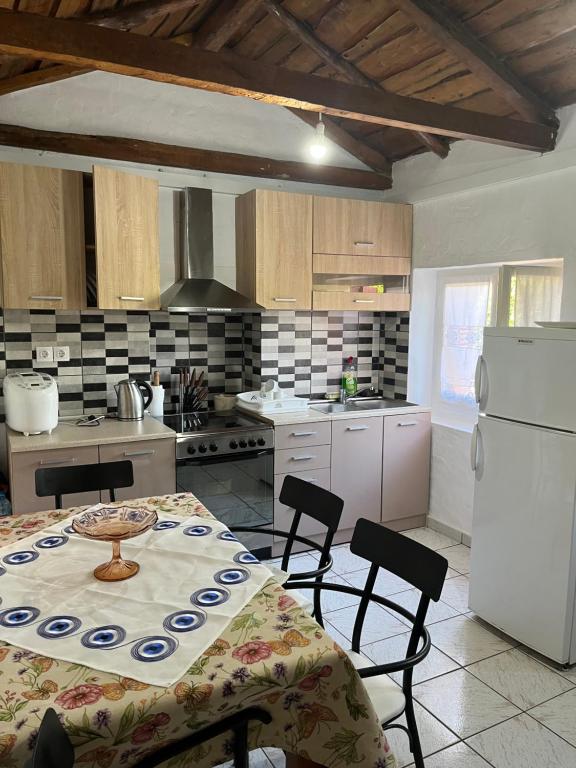 阿特帕克斯Rodovani Cottage的厨房配有桌椅和白色冰箱。