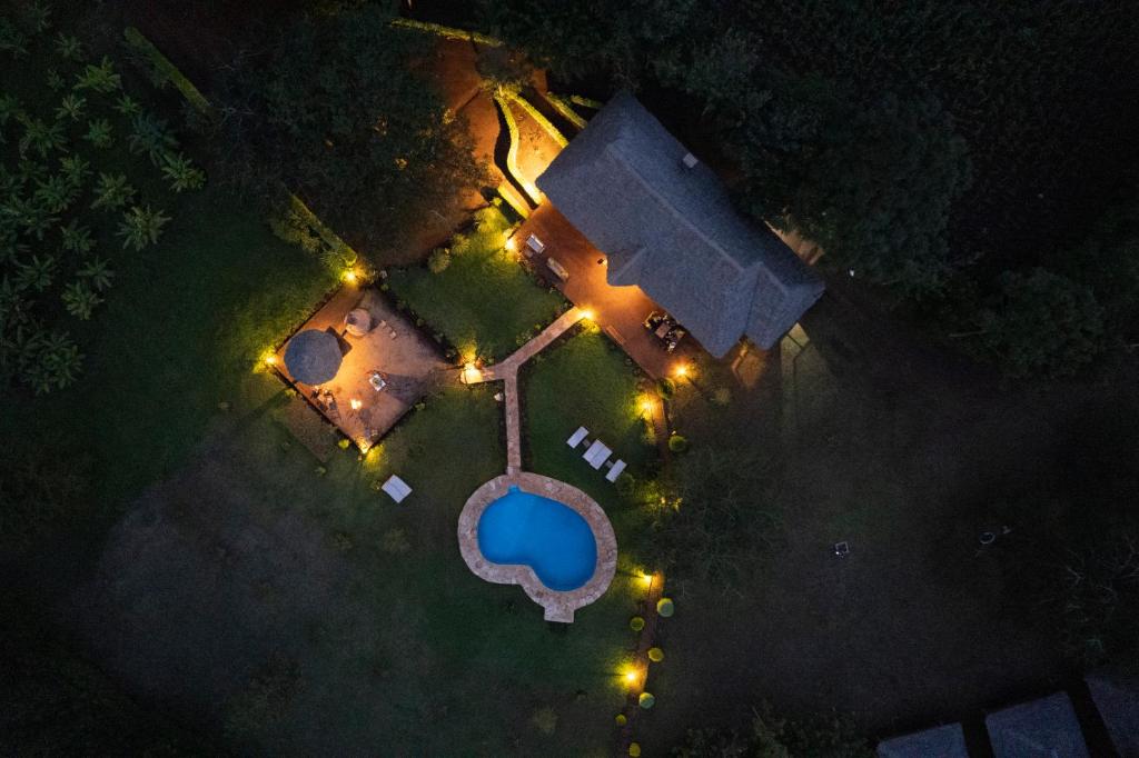 卡拉图Karatu Tented Lodge的享有泳池的顶部景色,晚上灯光照亮