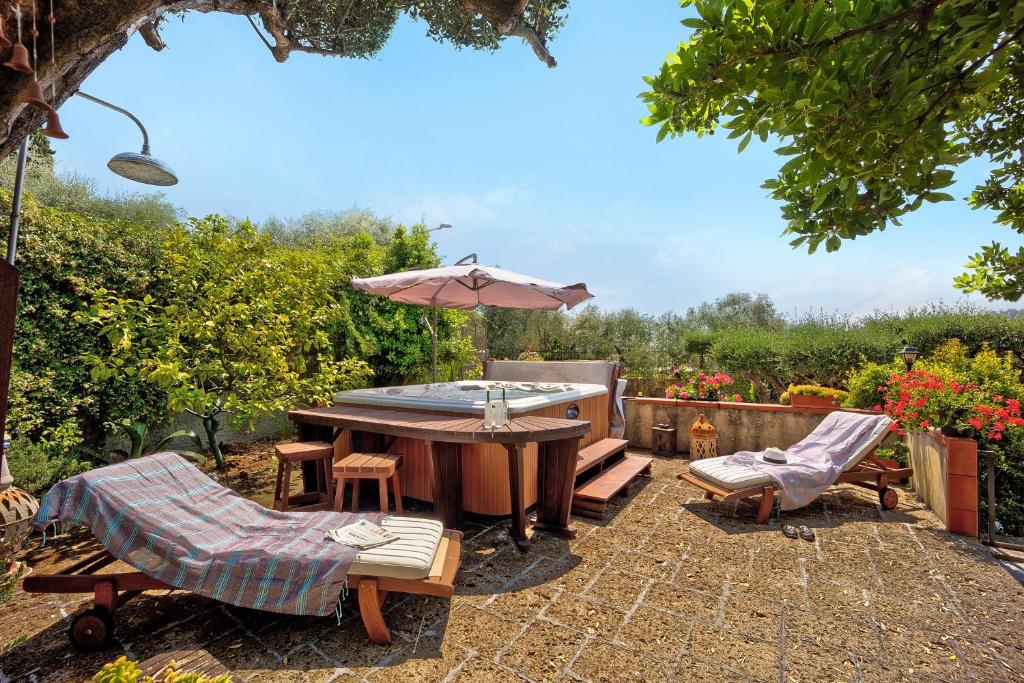 因佩里亚Ca dei Tati - Citra 1181的庭院配有桌子、遮阳伞和椅子