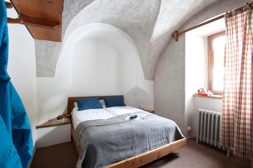 拉萨尔莱阿尔佩兰利老农庄酒店的一间卧室设有一张床和一个窗口