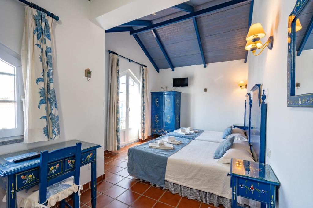 米尔芳提斯城Hotel Mar e Sol VNMF by Umbral的一间卧室配有床和两张蓝色的桌子