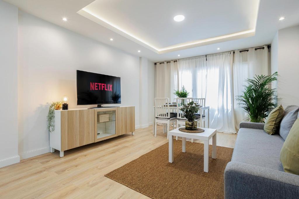 马德里GENESIS APARTMENT IN MADRID的带沙发、电视和桌子的客厅
