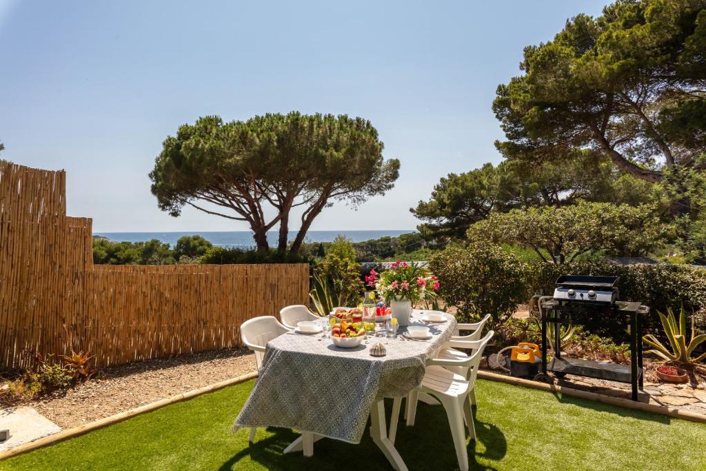 耶尔Le Photinia, mobil-home climatisé avec vue mer situé au cœur du domaine的后院设有围栏,配有桌椅