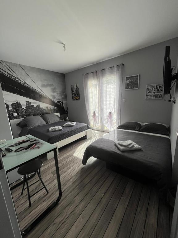 索恩河畔克雷什Chambres d'Hôtes chez Estelle的一间卧室配有两张床、一张桌子和一张书桌