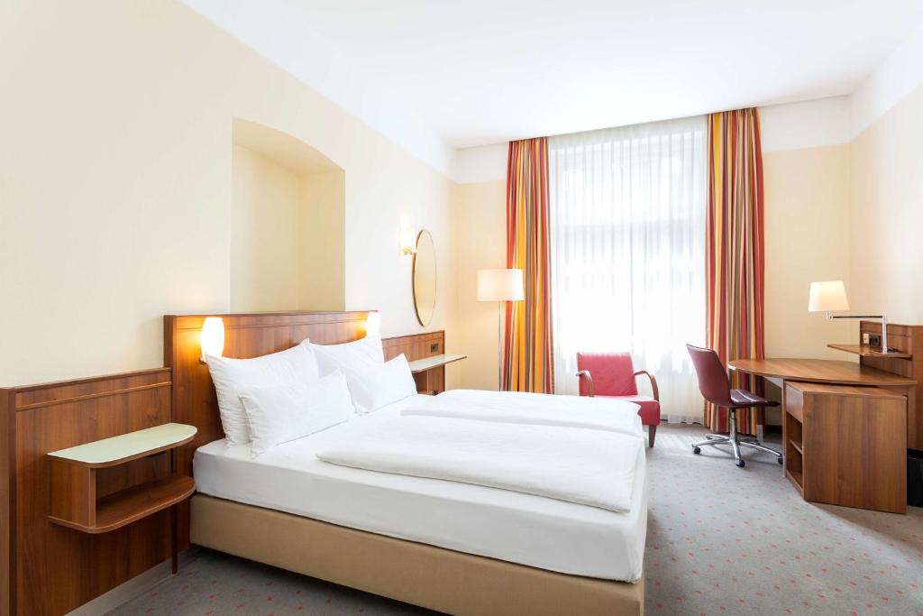 维也纳维也纳贝尔韦代雷NH酒店的配有一张床和一张书桌的酒店客房