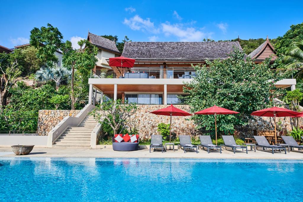 查汶Baan Jakawan的一座带红伞和游泳池的房子