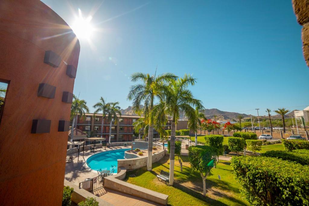 埃莫西约埃莫西约殖民风格酒店的享有带游泳池和棕榈树的度假村的景致
