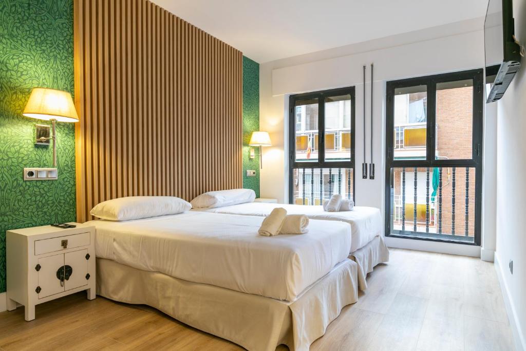 马德里H-A Aparthotel Hotel Quo的一间卧室设有两张床,拥有绿色的墙壁