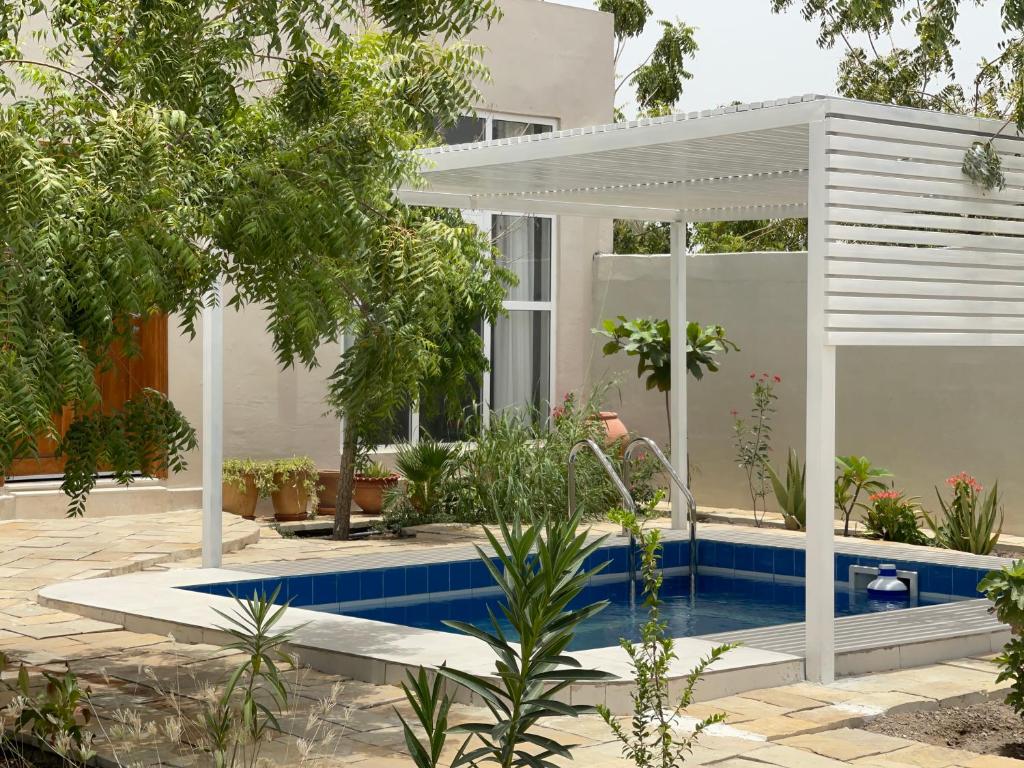 Al ḨamrāʼLittle Garden private pool villa的一座带游泳池和凉亭的房子