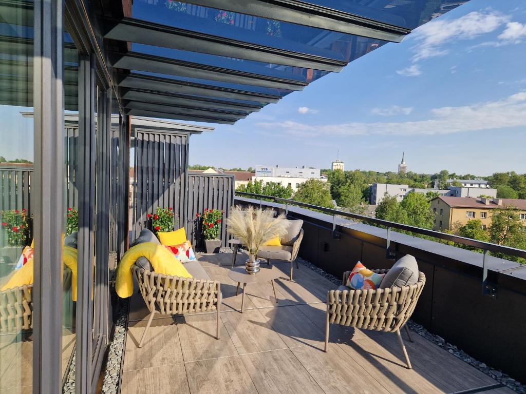 塔尔图Artisa Riia Str 20a Luxury 2BR Penthouse Apartment的屋顶上带桌椅的阳台
