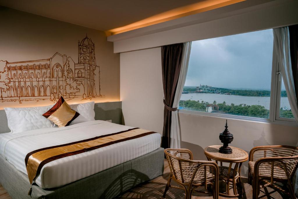 仰光The Rangoon Hotel的酒店客房设有一张床和一个大窗户