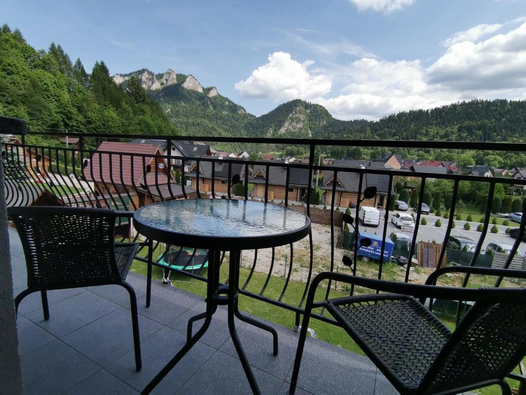 斯罗姆韦斯尼Noclegi na Wygonie的阳台配有2张桌子和椅子,享有山景。